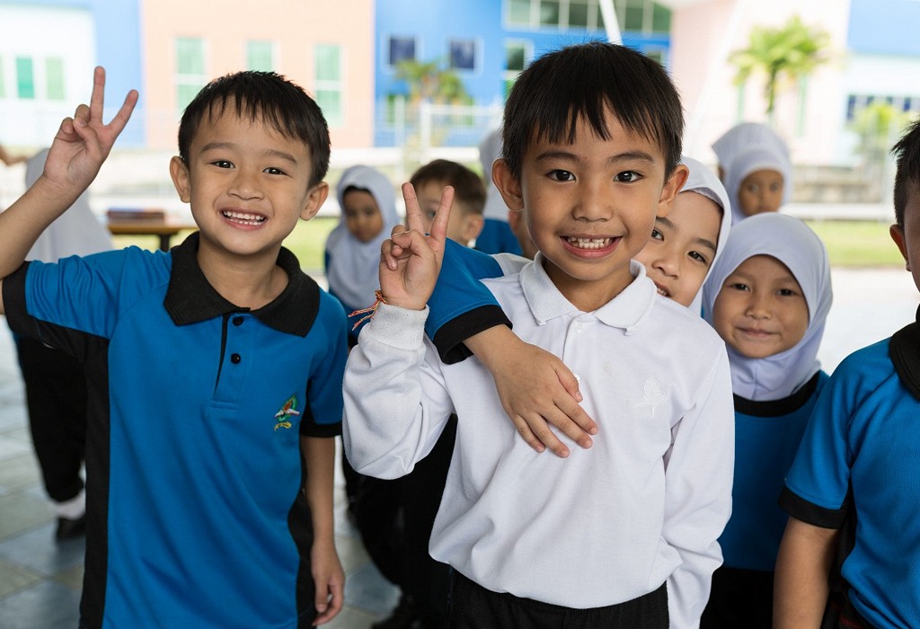 Kids in Brunei school smiling at camera